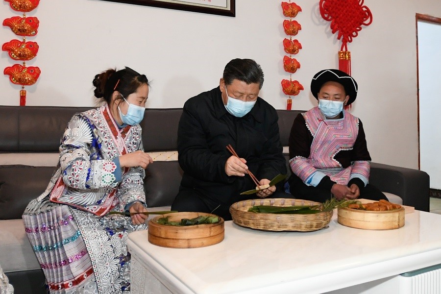 2021年2月3日下午，習(xí)近平在貴州畢節(jié)市黔西縣新仁苗族鄉(xiāng)化屋村苗族村民趙玉學(xué)家，同一家人邊聊家常邊制作當(dāng)?shù)貍鹘y(tǒng)節(jié)日食品黃粑。新華社記者 李學(xué)仁 攝